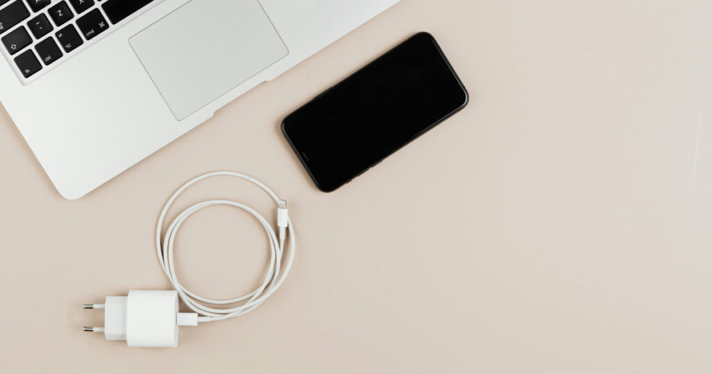 スマートフォンとケーブルと充電器、パソコンの画像